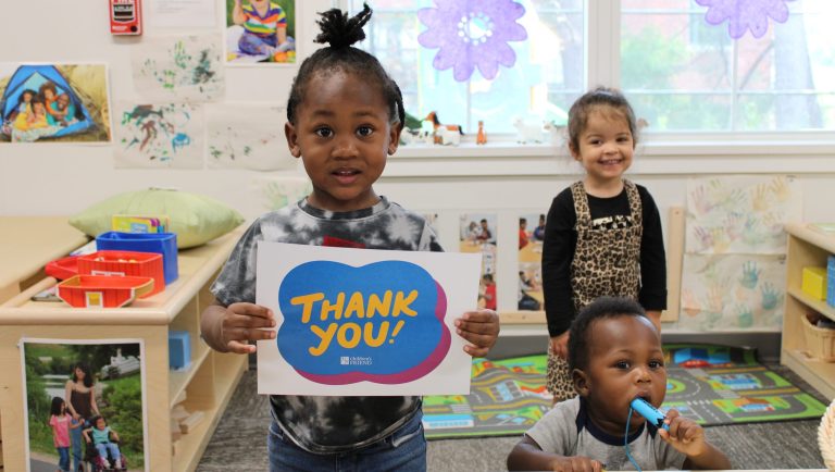 Toddler holds a sign that says "thank you"